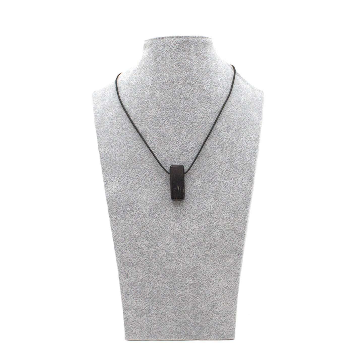 Anhänger in länglicher Rechteckform, petit aus schwarzem Turmalin (Schörl) an einem schwarzen Lederband befestigt und an einer Schmuckbüste gezeigt.